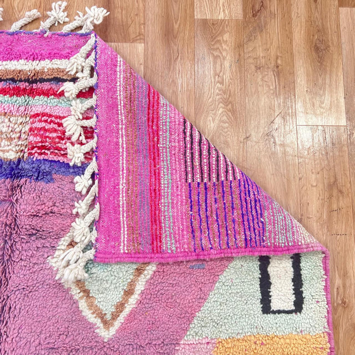 Vintage Moroccan wool rug with pink base and colorful Berber geometric diamond patterns, handmade in Morocco.