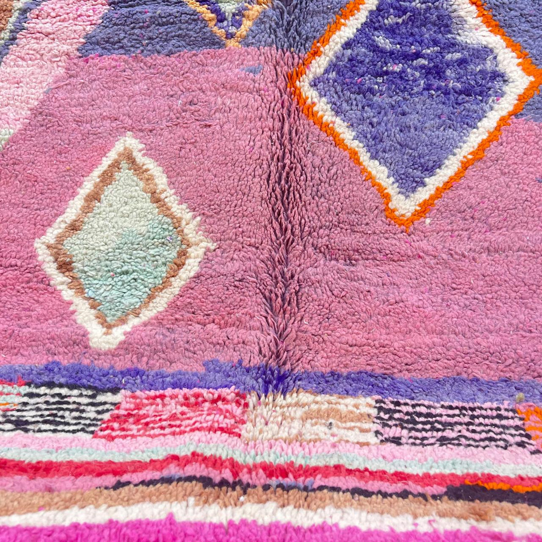 Vintage Moroccan wool rug with pink base and colorful Berber geometric diamond patterns, handmade in Morocco.