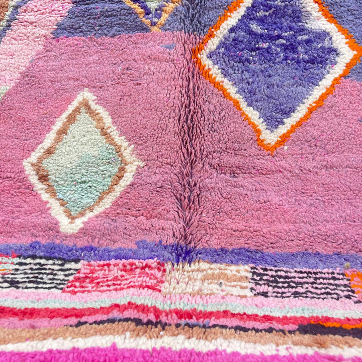 Vintage Moroccan wool rug with pink base and colorful Berber geometric diamond patterns, handmade in Morocco.