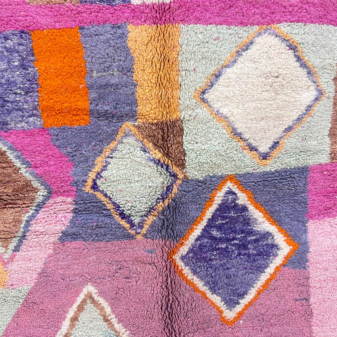 Vintage Moroccan wool rug with pink base and colorful Berber geometric diamond patterns, handmade in Morocco.