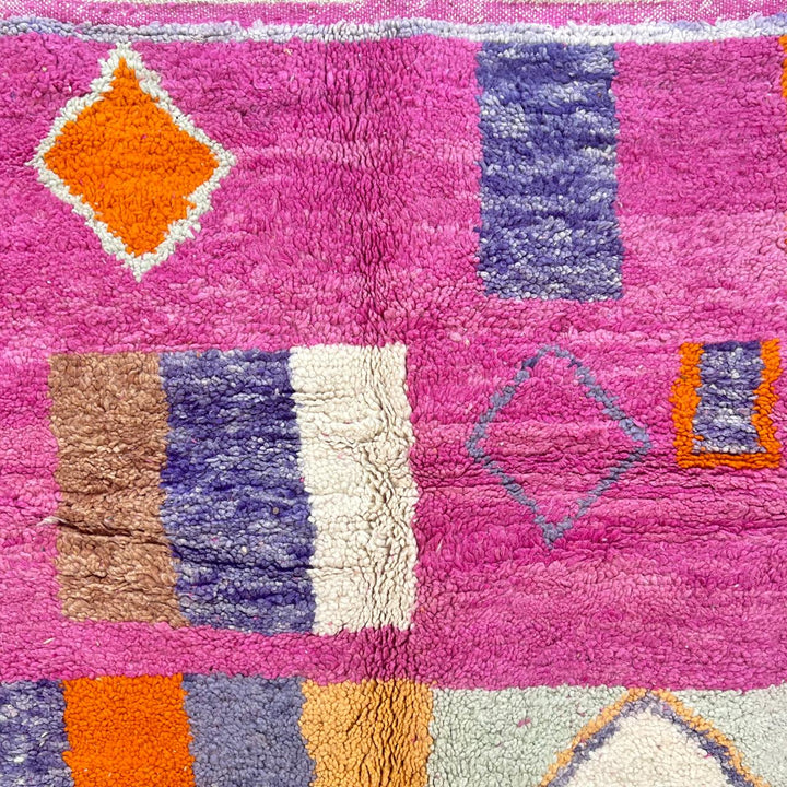 Vintage Moroccan wool rug with pink base and colorful Berber geometric diamond patterns, handmade in Morocco.