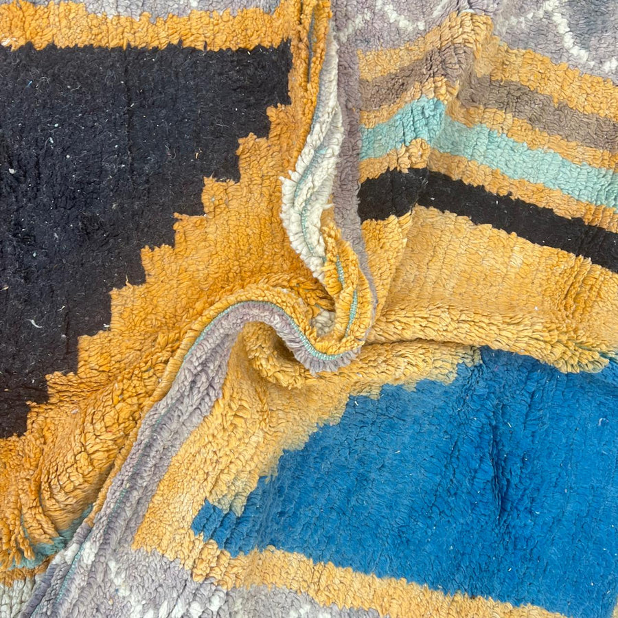 Vintage Moroccan wool rug with yellow base and blue, black Berber geometric patterns, handmade in Morocco.