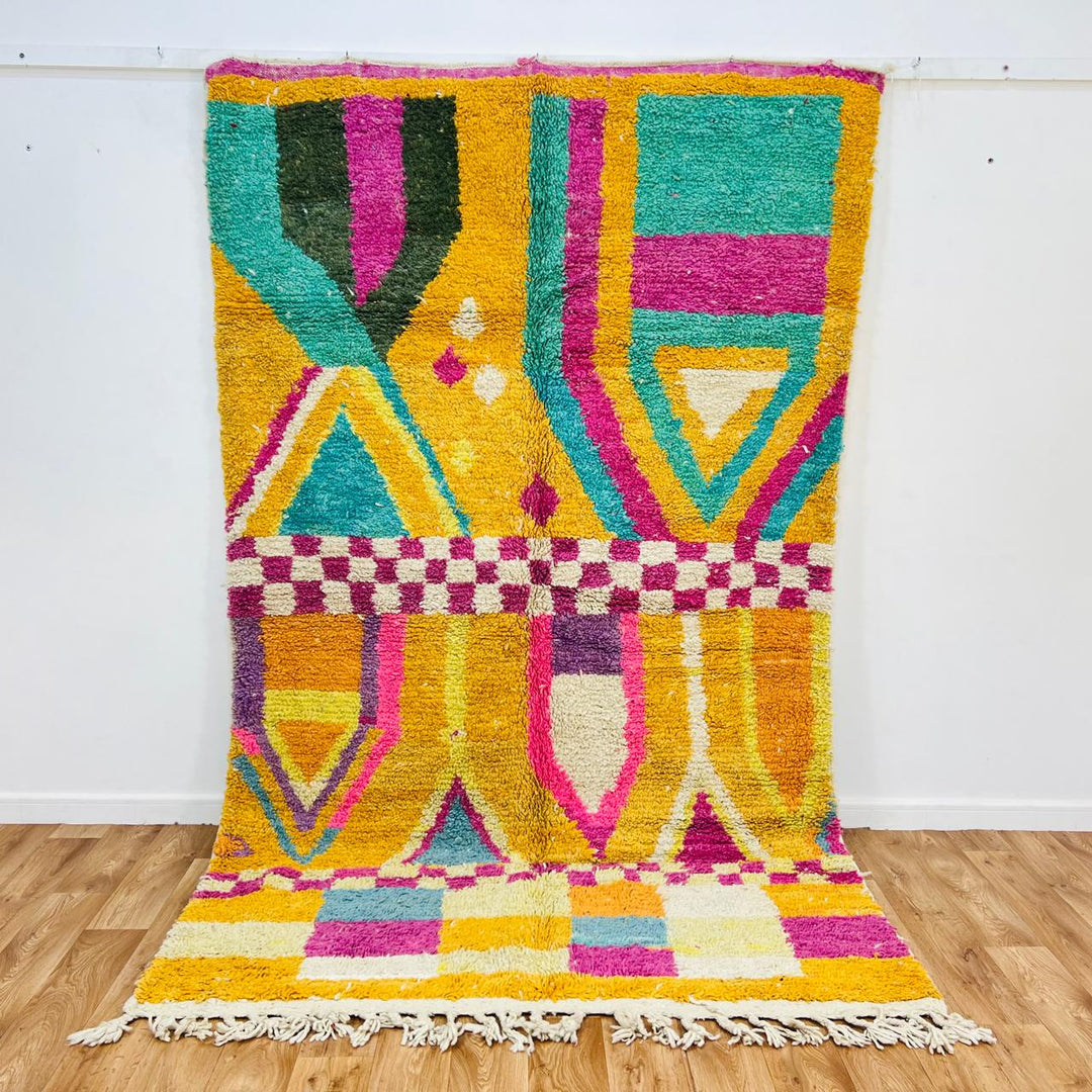 Vintage Moroccan rug with colorful Berber geometric patterns in mustard yellow, turquoise, pink, and cream wool