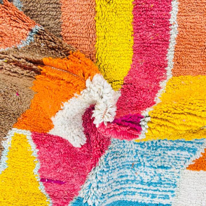 Vintage Moroccan wool rug with colorful abstract Berber pattern in yellow, pink, blue, and orange tones, handmade in Morocco