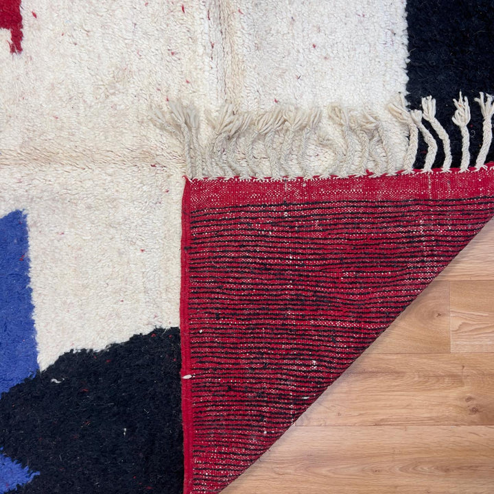 Vintage Moroccan wool rug in deep red with abstract black, ivory, and blue color blocks, handmade Berber rug