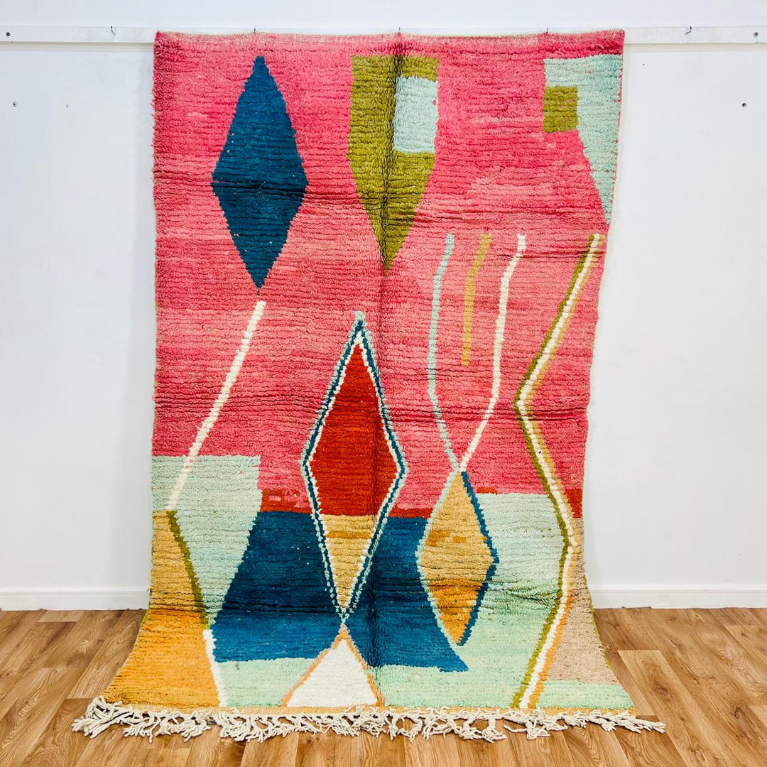 Vintage Moroccan wool rug with pink background and colorful Berber geometric symbols, handmade in Morocco