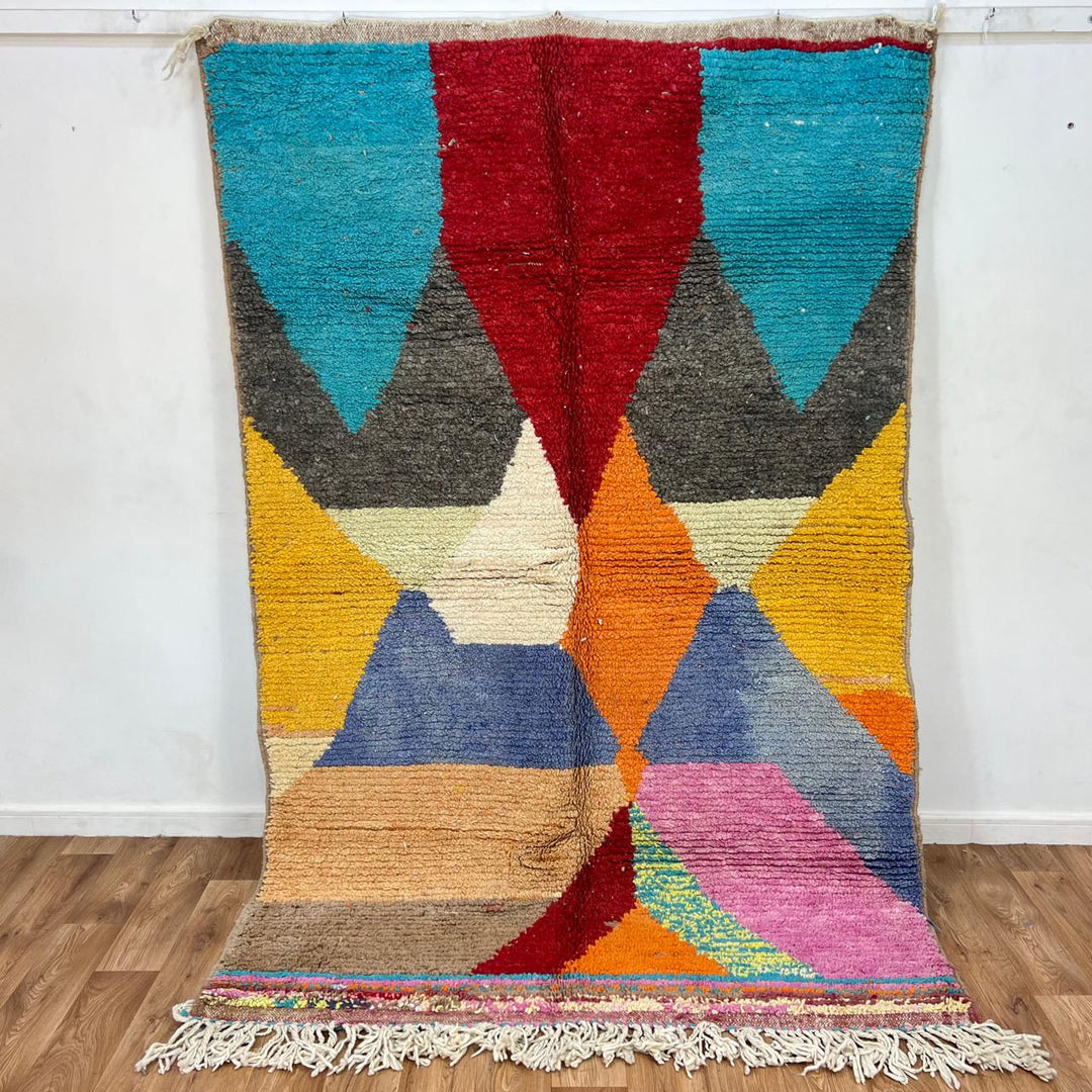 Vintage Moroccan wool rug with bold geometric Berber patterns in turquoise, red, and mustard