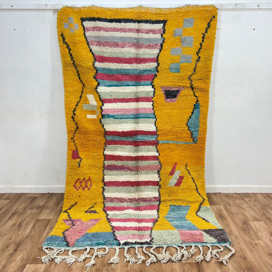 Vintage Moroccan wool rug with mustard yellow background and central striped pastel panel, abstract geometric Berber carpet 265x153 cm
