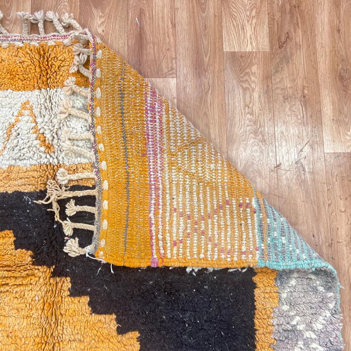 Vintage Moroccan wool rug with yellow base and blue, black Berber geometric patterns, handmade in Morocco.