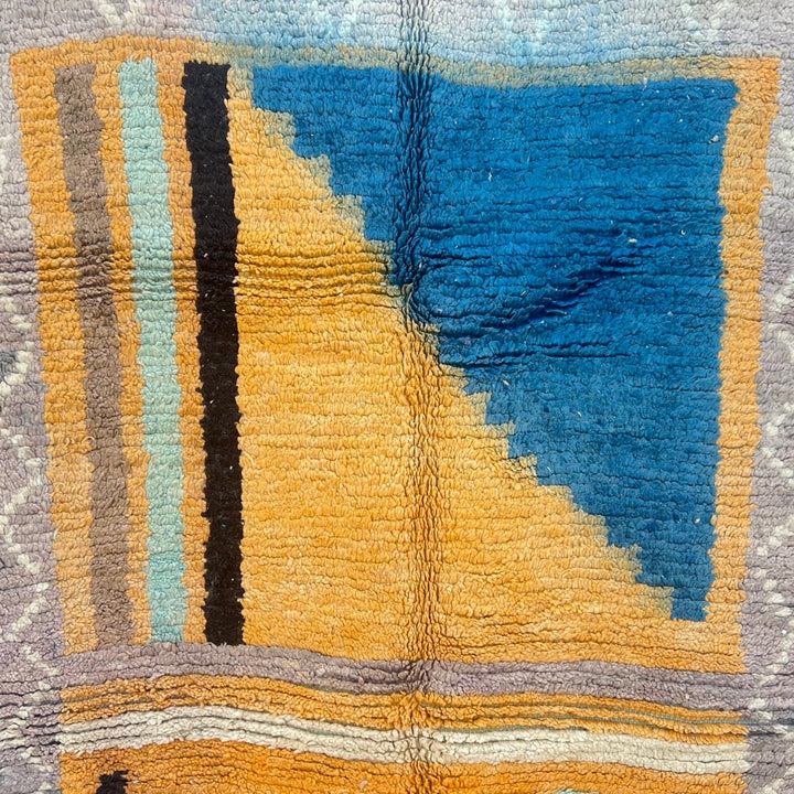 Vintage Moroccan wool rug with yellow base and blue, black Berber geometric patterns, handmade in Morocco.