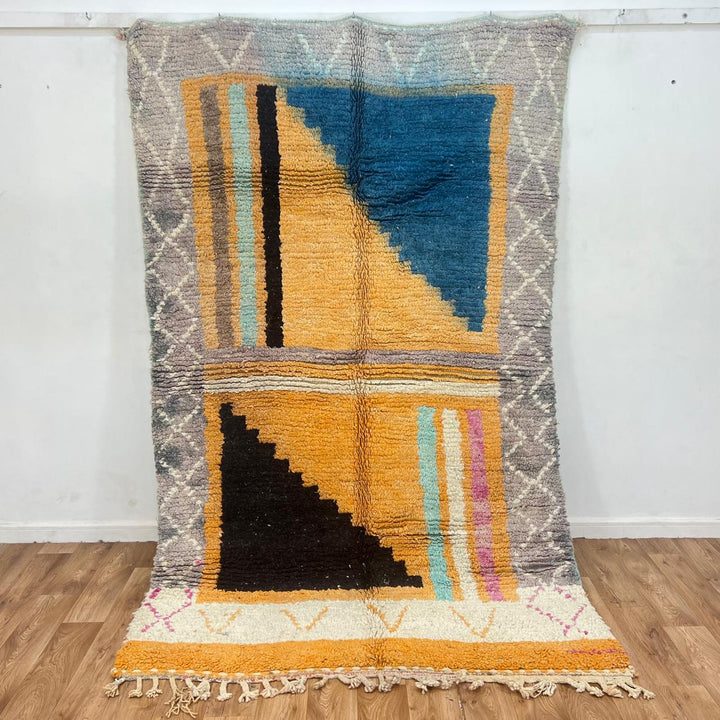 Vintage Moroccan wool rug with yellow base and blue, black Berber geometric patterns, handmade in Morocco.