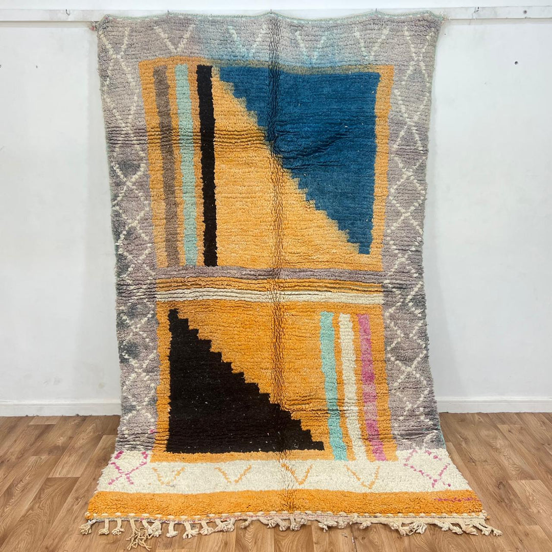 Vintage Moroccan wool rug with yellow base and blue, black Berber geometric patterns, handmade in Morocco.