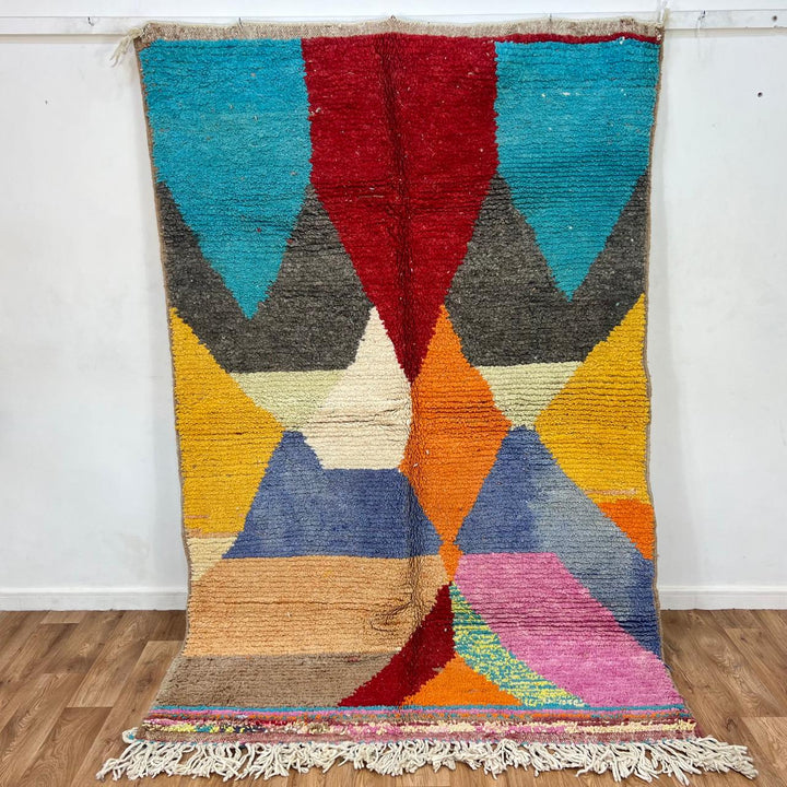 Vintage Moroccan wool rug with bold geometric Berber patterns in turquoise, red, and mustard