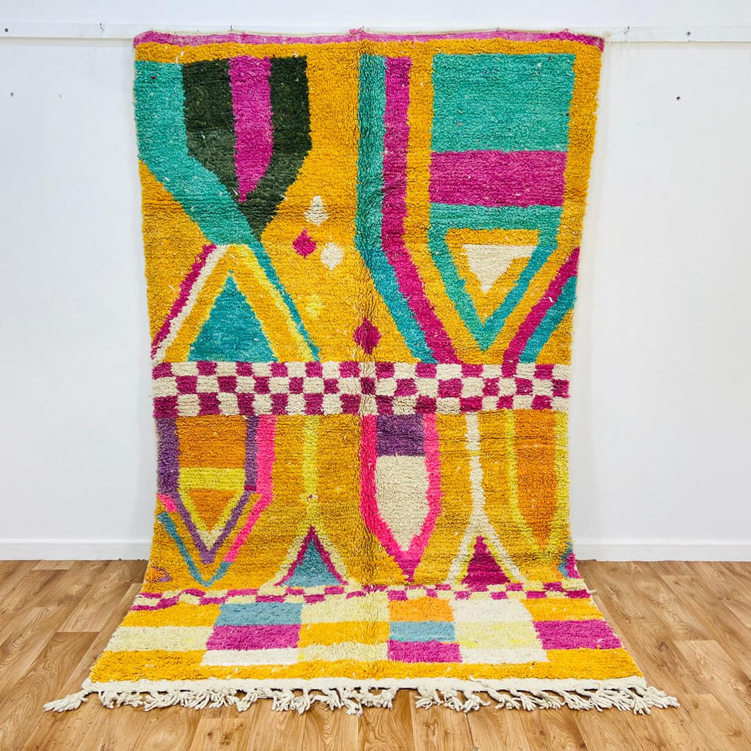Vintage Moroccan rug with colorful Berber geometric patterns in mustard yellow, turquoise, pink, and cream wool