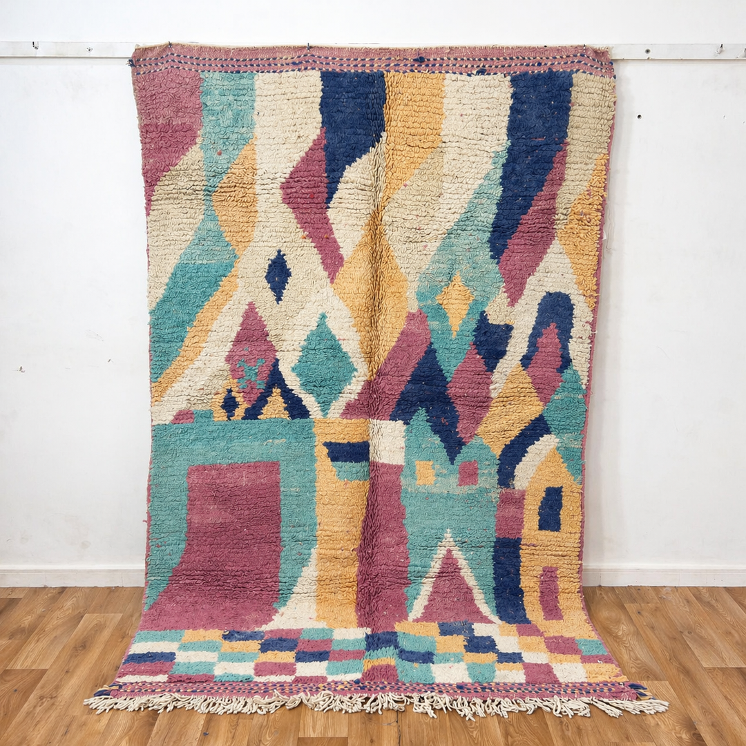 Vintage Moroccan wool rug 8.20 x 5.38 ft Rug 76 with abstract pastel design in pink, mint green, beige and blue tones, handmade Berber rug displayed on wooden floor