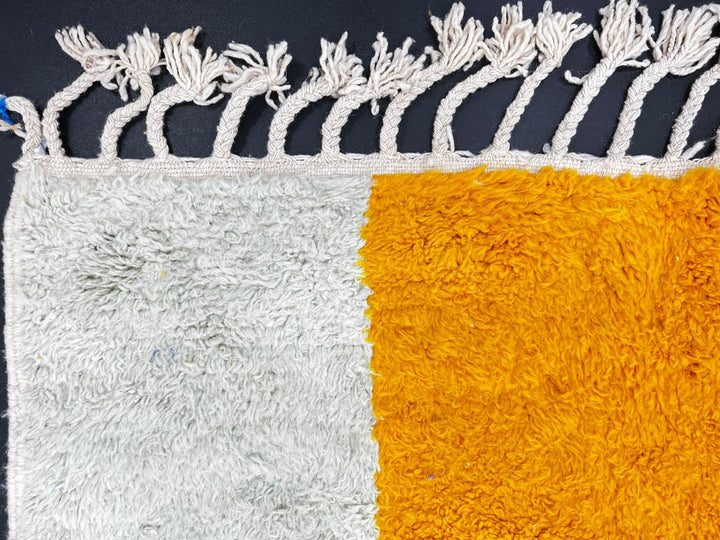 Colorful Moroccan wool rug with pink, blue, and yellow color block abstract design, handmade by Berber artisans