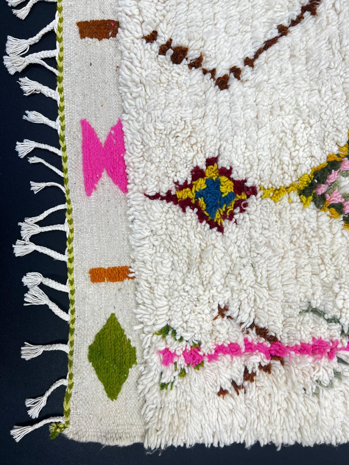 Handmade white Moroccan runner rug with colorful Berber diamond motifs and tribal patterns, crafted from natural wool for hallways and modern interiors.