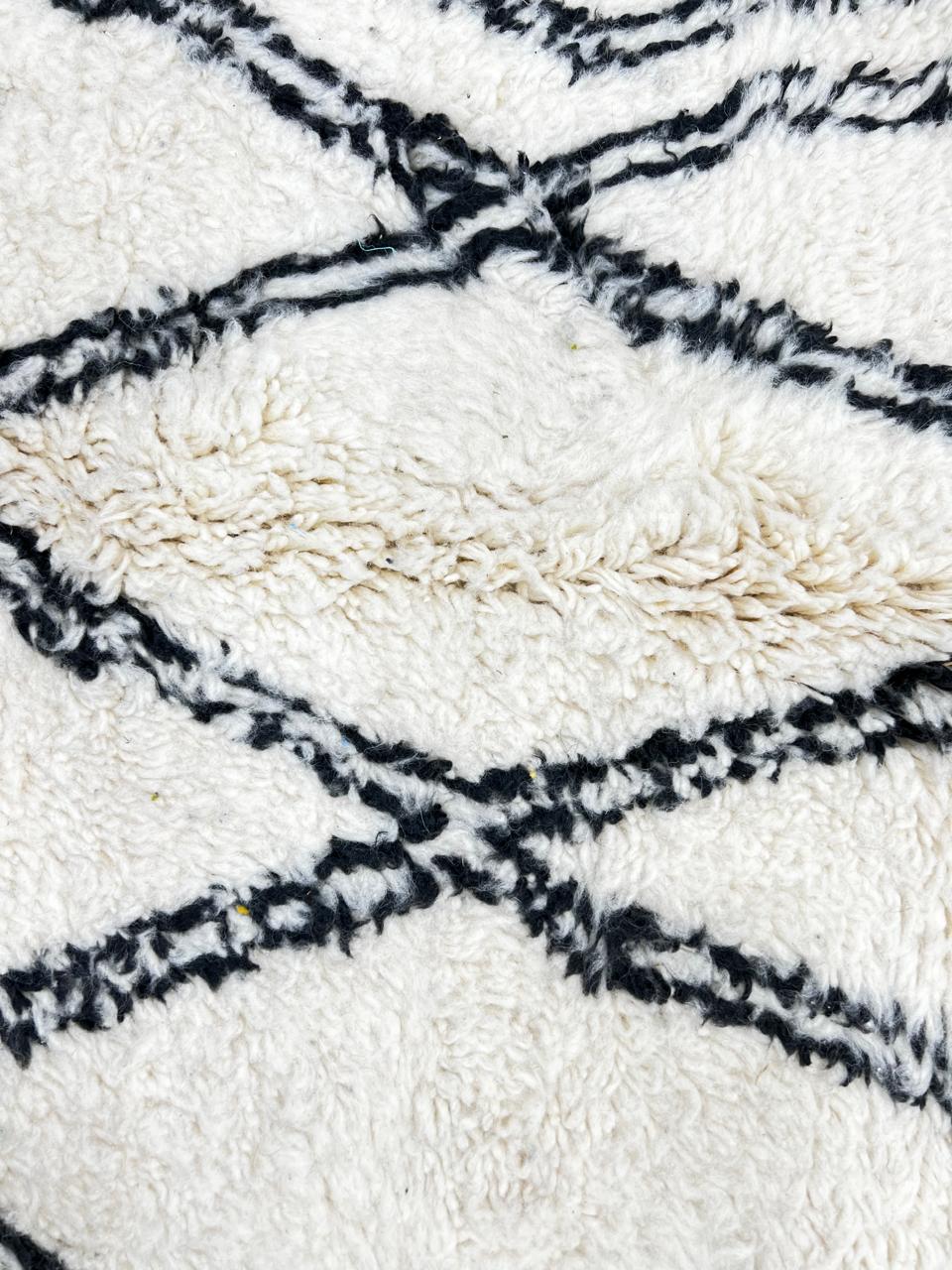 Handmade white Moroccan runner rug with black diamond lattice pattern in natural wool, Berber inspired design.