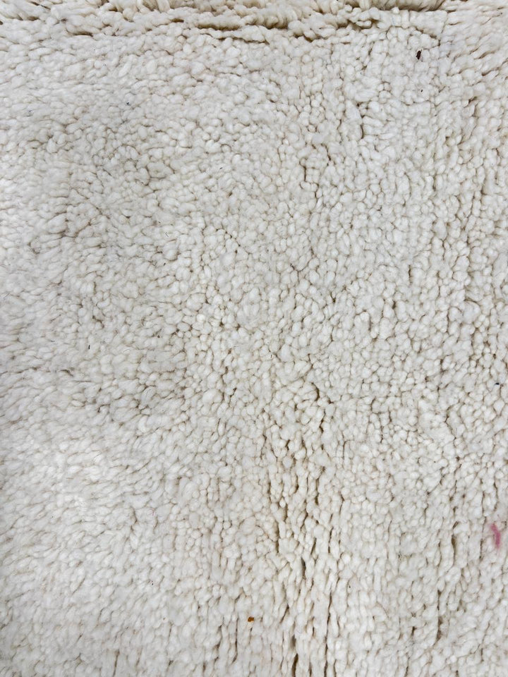 Handmade Moroccan runner rug in solid white natural wool with minimalist tassels, crafted by Berber artisans.