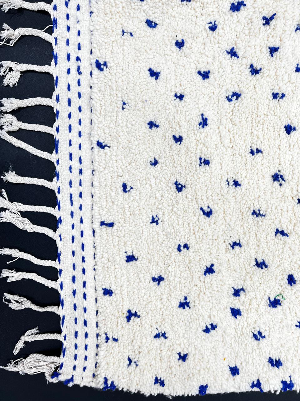 Handmade white Moroccan runner rug with small blue dotted pattern, woven from natural wool by Berber artisans.