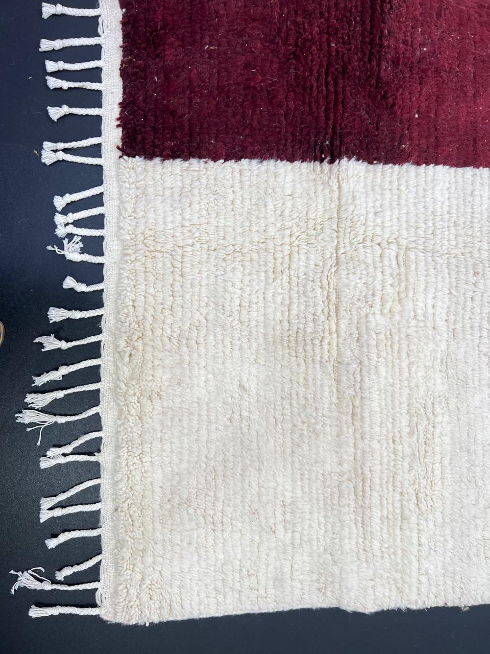 White Moroccan runner rug with a deep red vertical stripe and purple horizontal stripe, handmade from natural wool