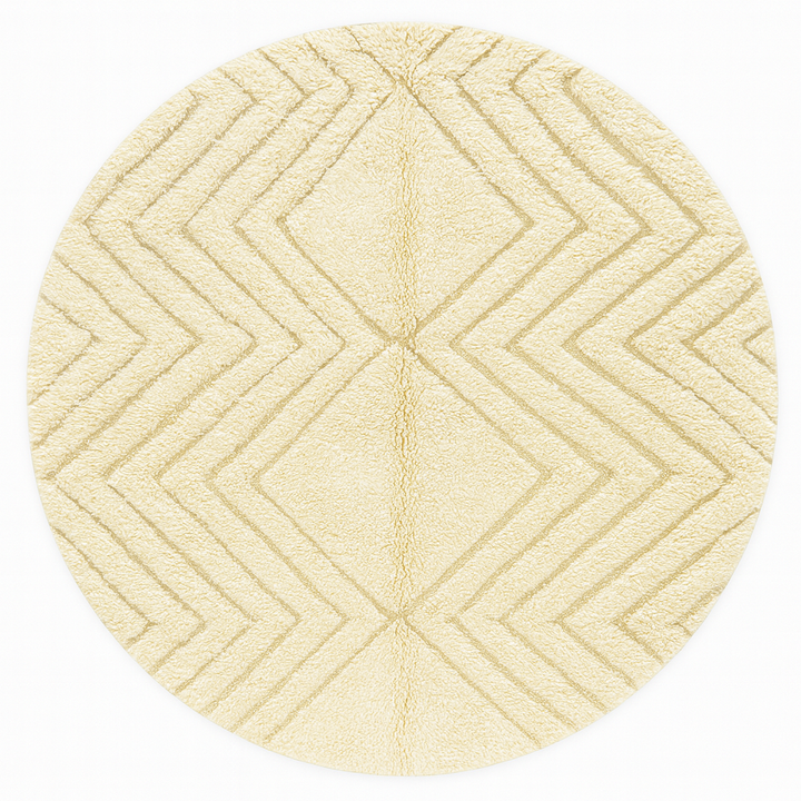 Round white Moroccan wool rug with carved geometric diamond and chevron patterns.