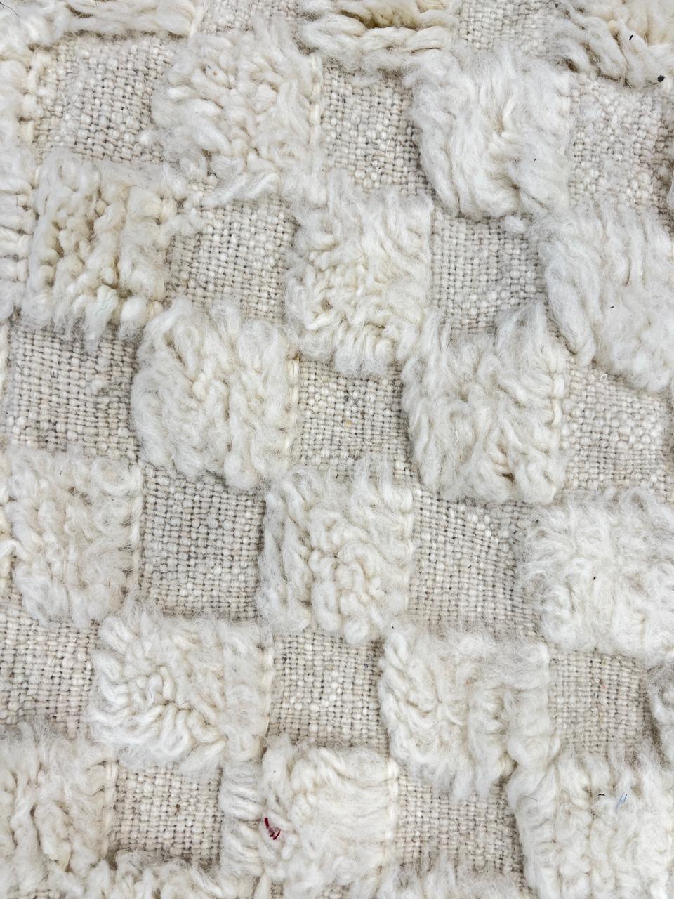 Round white Moroccan wool rug with raised checkered 3D texture.