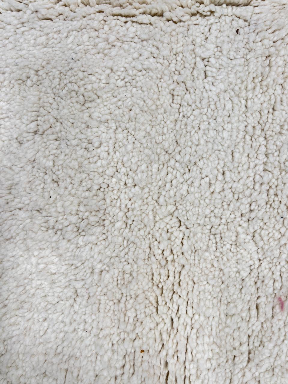 Round white Moroccan wool rug with soft plush texture and minimalist design.