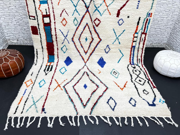 Handmade white Moroccan wool rug with blue, red, and orange geometric motifs – Berber design