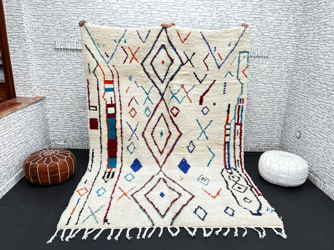 Handmade white Moroccan wool rug with blue, red, and orange geometric motifs – Berber design