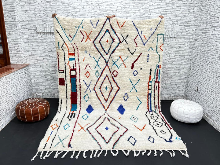 Handmade white Moroccan wool rug with blue, red, and orange geometric motifs – Berber design