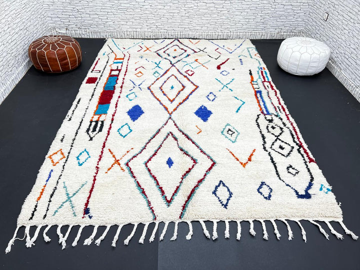 Handmade white Moroccan wool rug with blue, red, and orange geometric motifs – Berber design