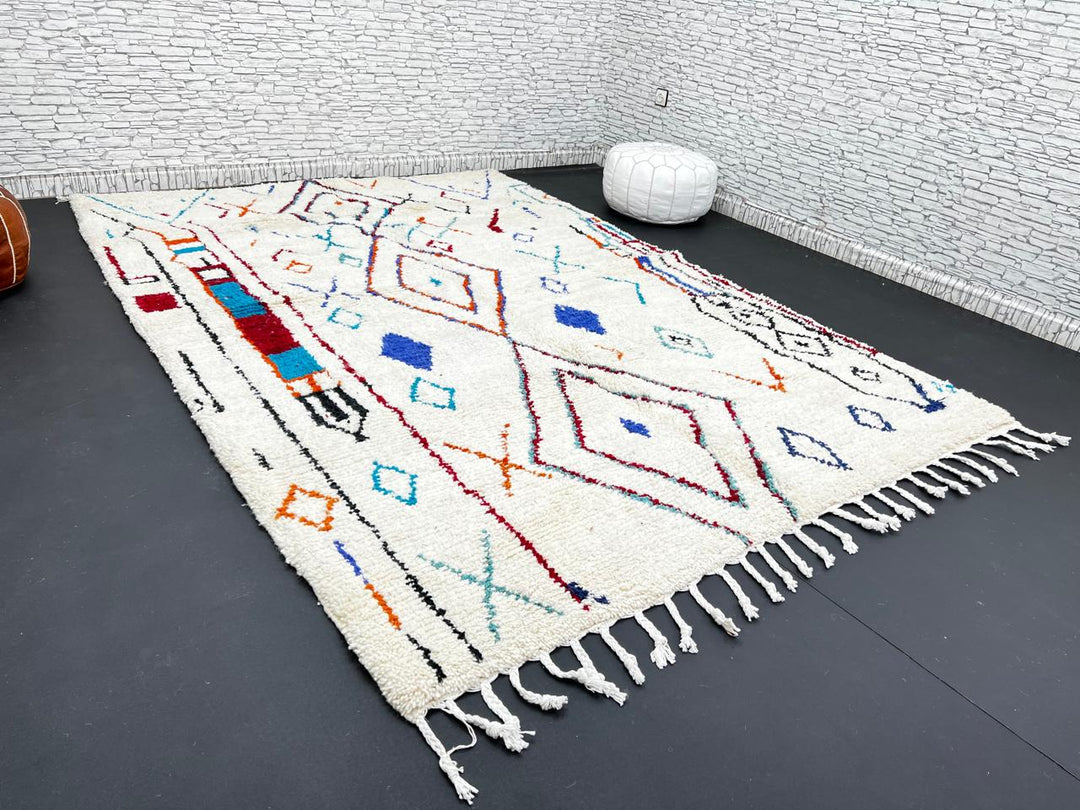 Handmade white Moroccan wool rug with blue, red, and orange geometric motifs – Berber design