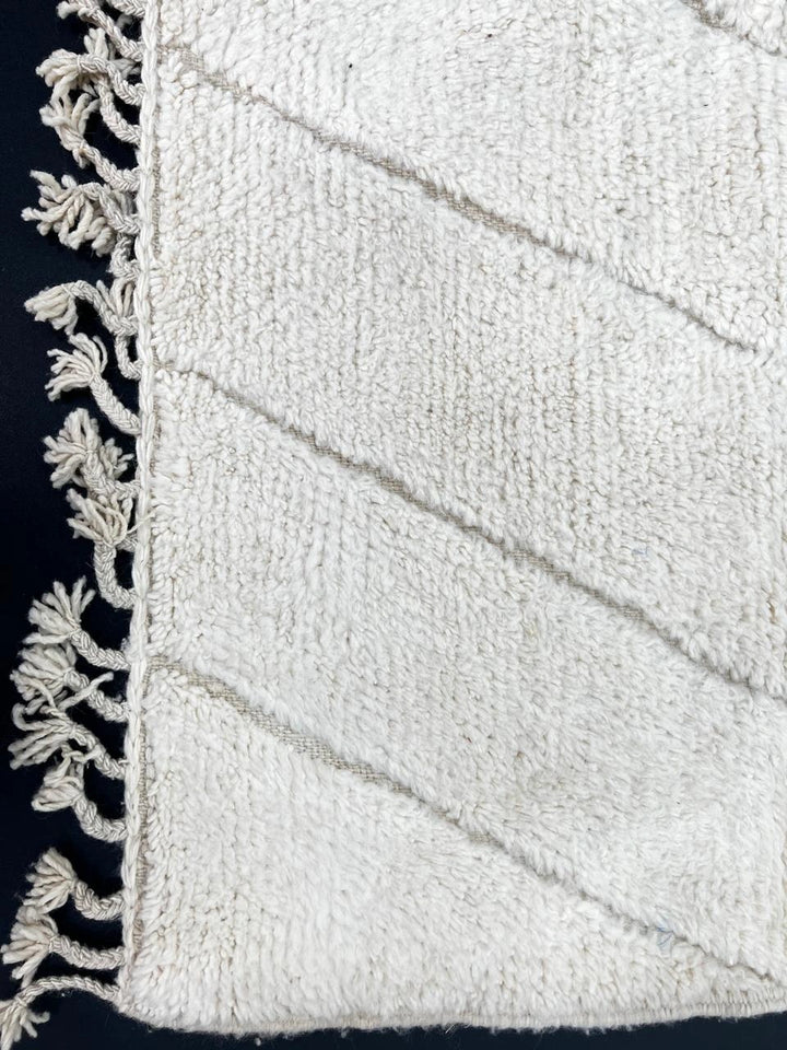 Handmade white Moroccan wool runner rug with minimalist geometric carved pattern