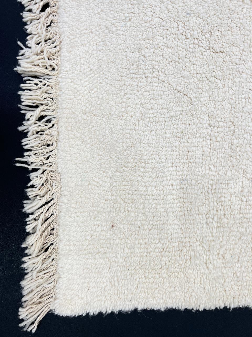 Handmade Moroccan runner rug in solid white natural wool with minimalist tassels, crafted by Berber artisans.