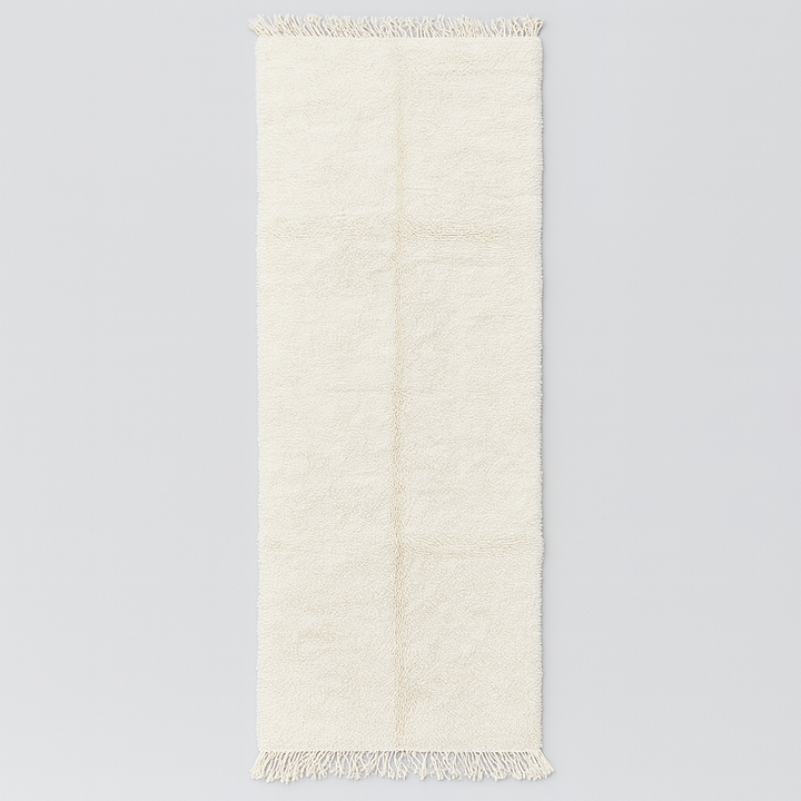 Handmade Moroccan runner rug in solid white natural wool with minimalist tassels, crafted by Berber artisans.
