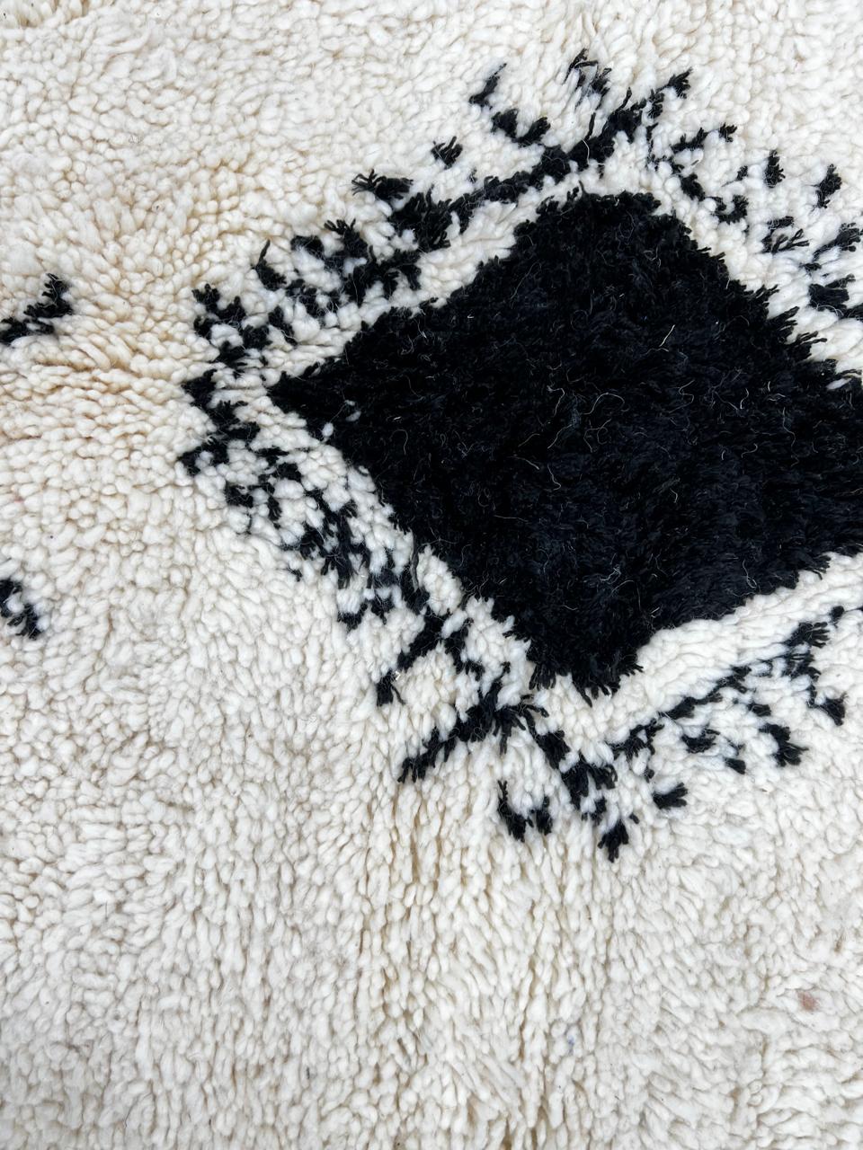 Handmade white Moroccan runner rug with black tribal Berber symbols and diamond patterns.