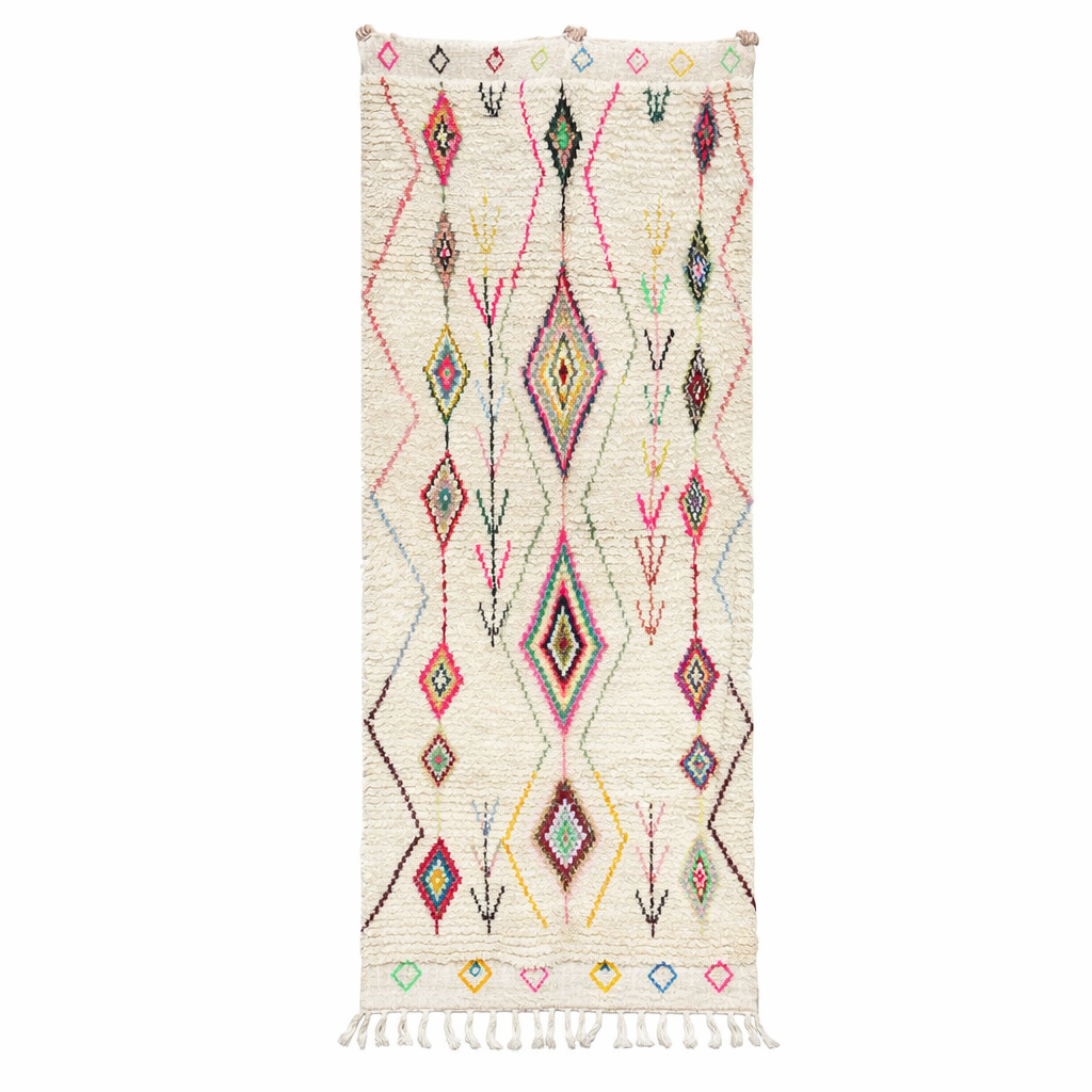 Handmade white Moroccan wool runner rug with colorful Berber diamond motifs in pink, green, yellow, turquoise, and black