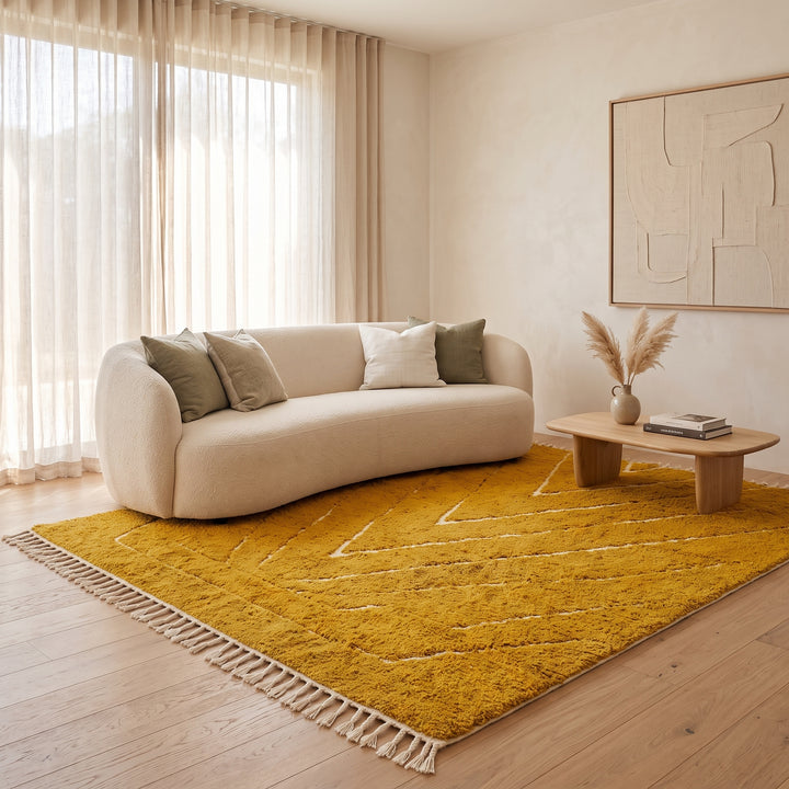 Handmade mustard yellow Moroccan wool rug with ivory geometric lines, plush texture and white tassel fringe.
