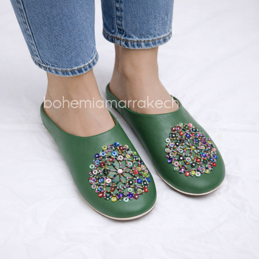 Green handmade Moroccan leather babouche slippers with colorful beaded medallion.