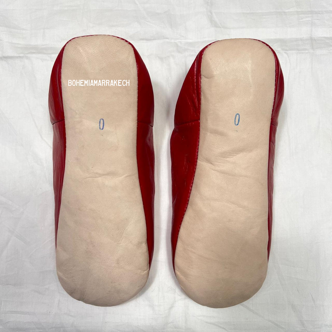 Red handmade Moroccan leather babouche slippers, traditional style.
