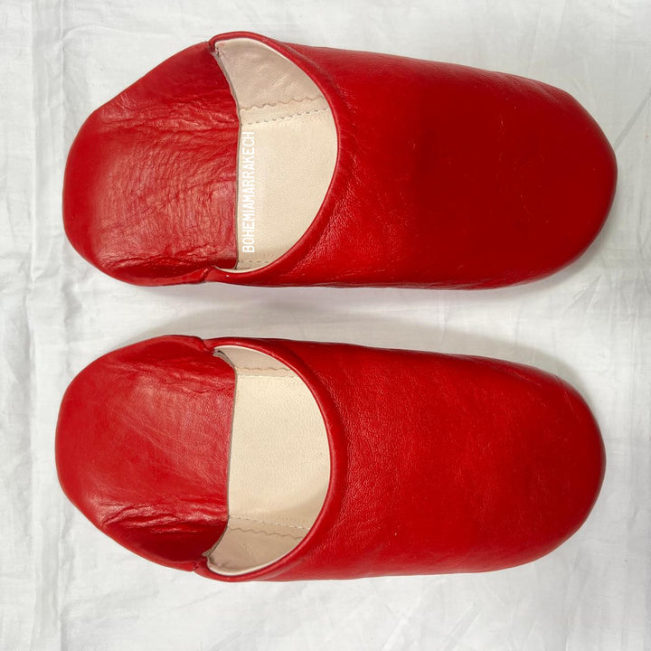 Red handmade Moroccan leather babouche slippers, traditional style.