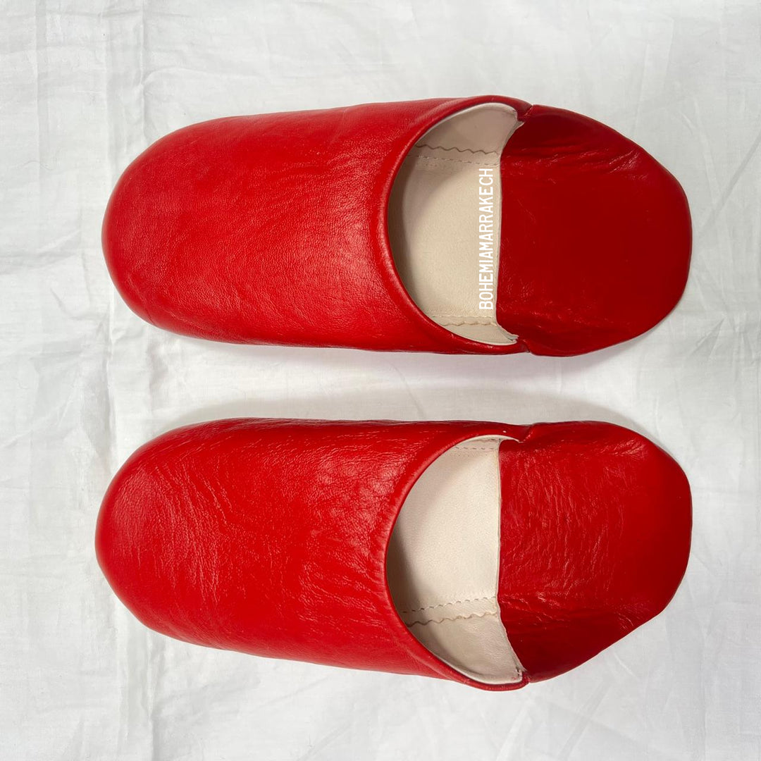 Red handmade Moroccan leather babouche slippers, traditional style.