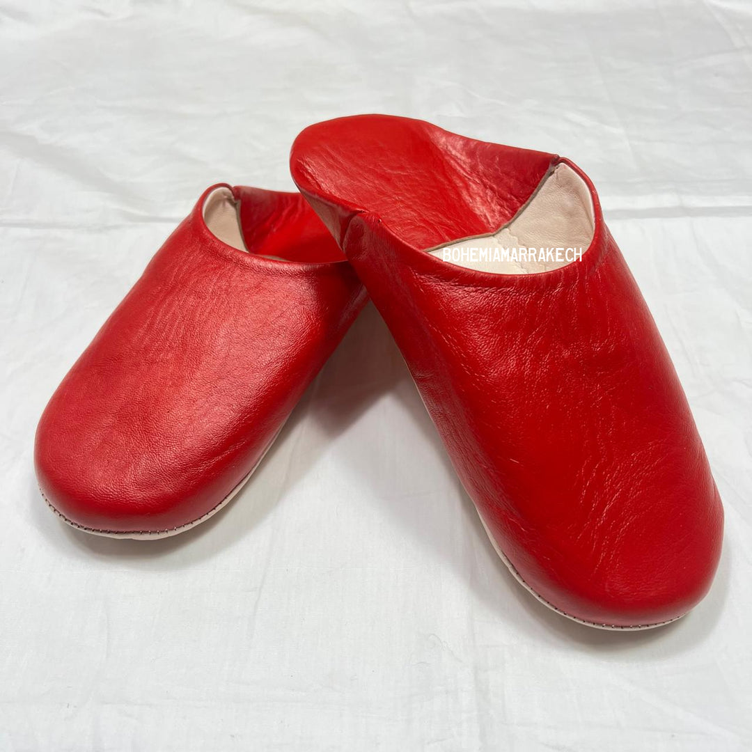 Red handmade Moroccan leather babouche slippers, traditional style.