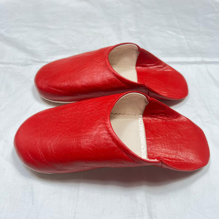 Red handmade Moroccan leather babouche slippers, traditional style.