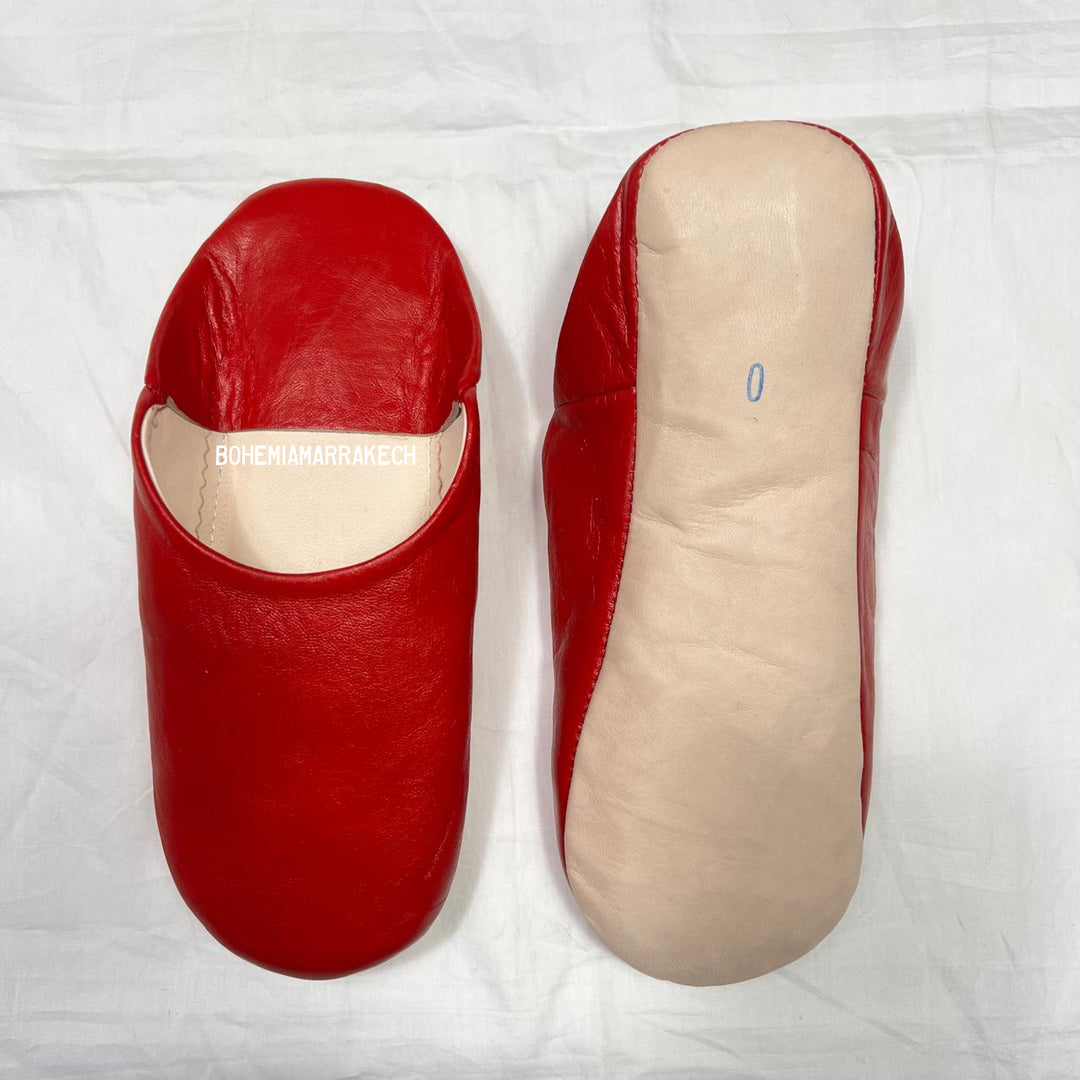 Red handmade Moroccan leather babouche slippers, traditional style.