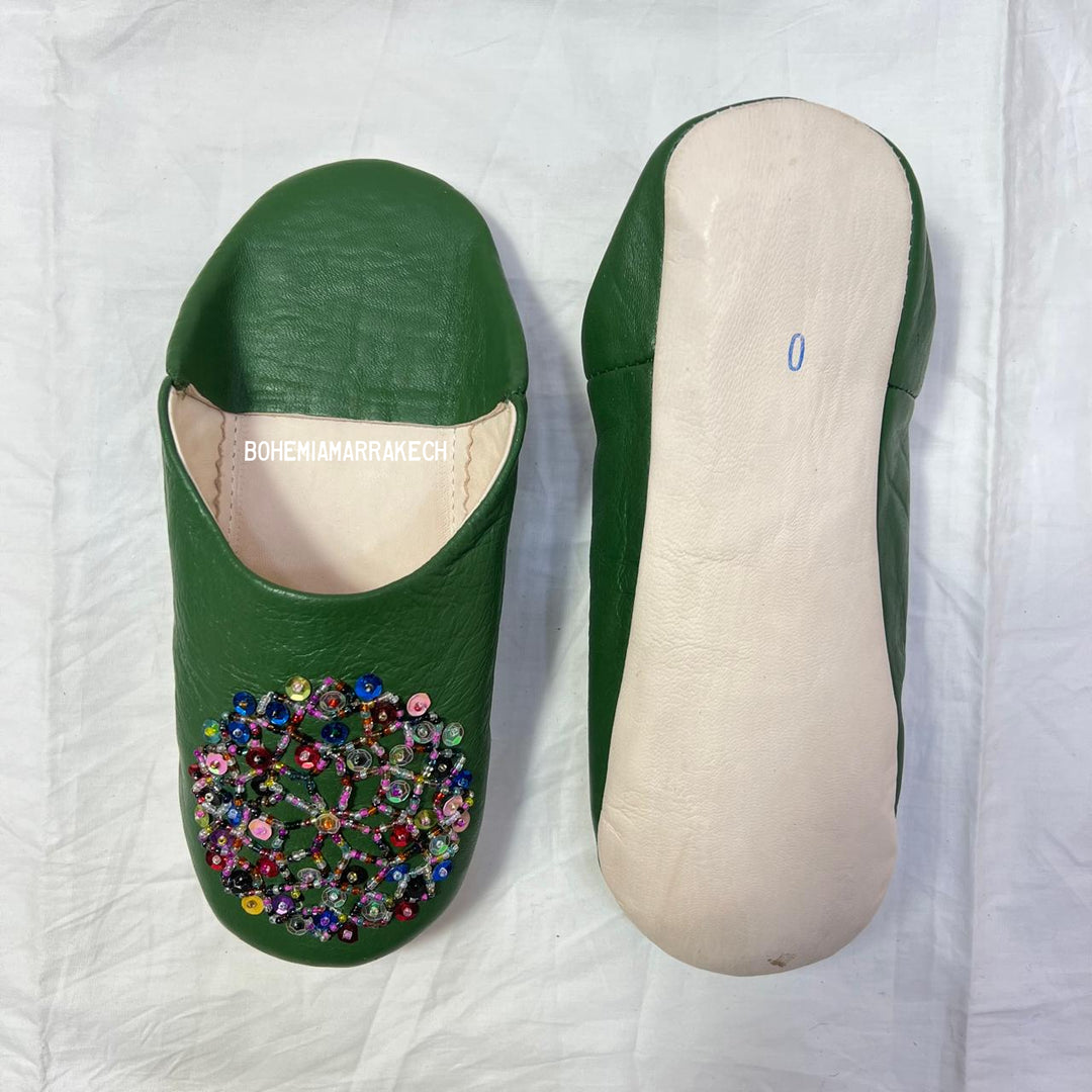 Green handmade Moroccan leather babouche slippers with colorful beaded medallion.