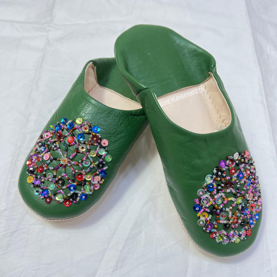Green handmade Moroccan leather babouche slippers with colorful beaded medallion.