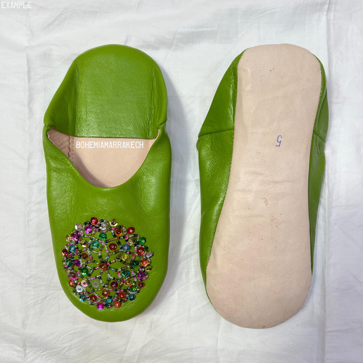 Handmade Moroccan leather babouche slippers with traditional pointed shape and simple hand stitching.