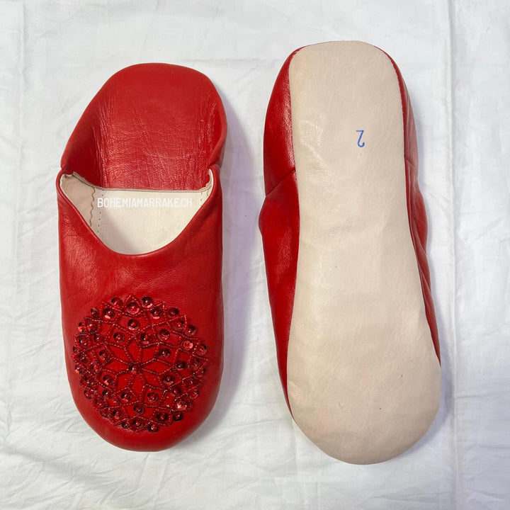 Artisan-made Moroccan babouche slippers with simple stitched details.